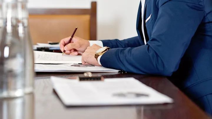 Personne signant un document à une table de réunion