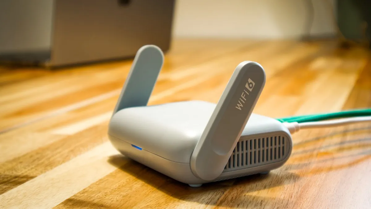 Routeur Wi-Fi grand public posé sur un bureau, câble réseau branché